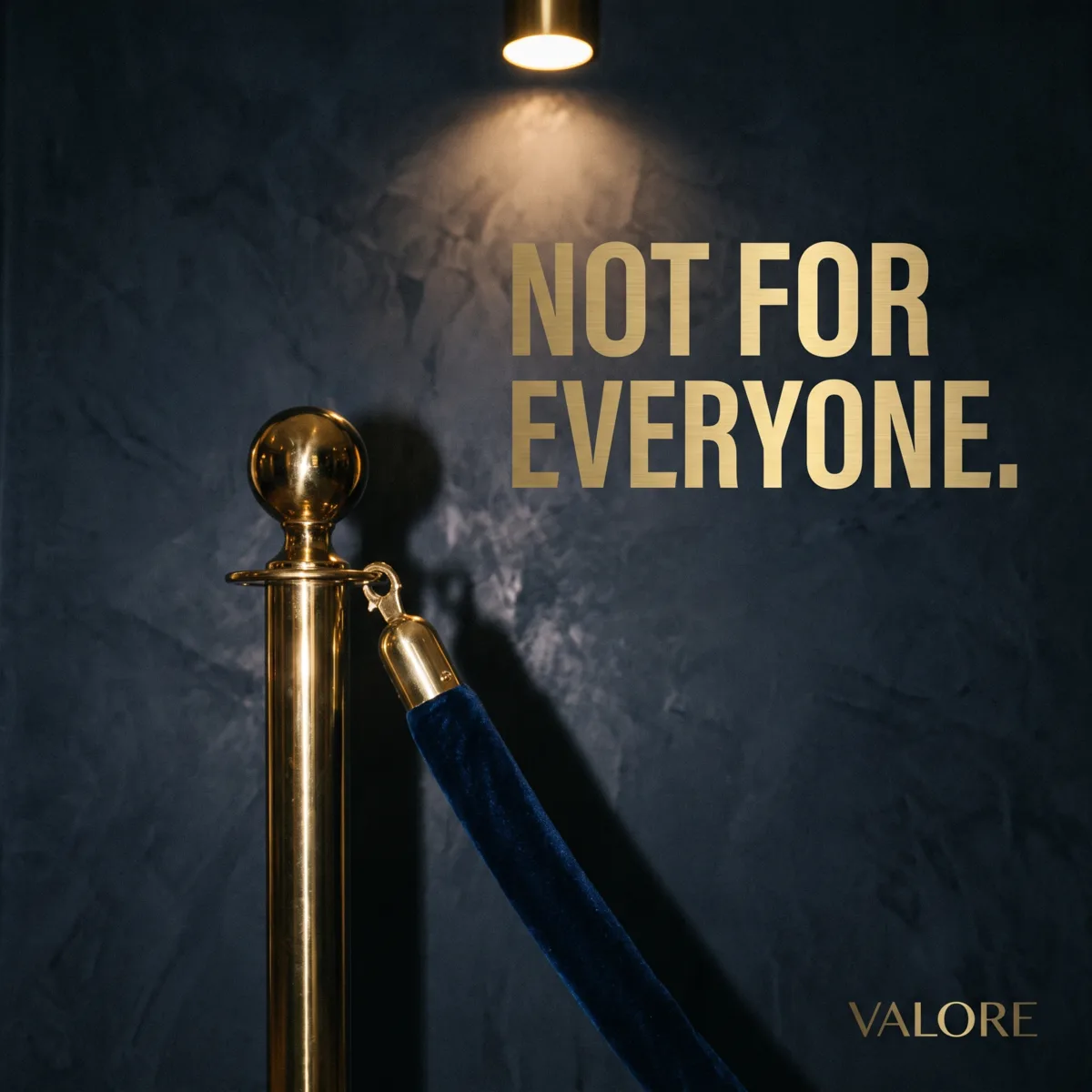 A brass stanchion and navy velvet rope under a spotlight with the words Not For Everyone, by Valore
